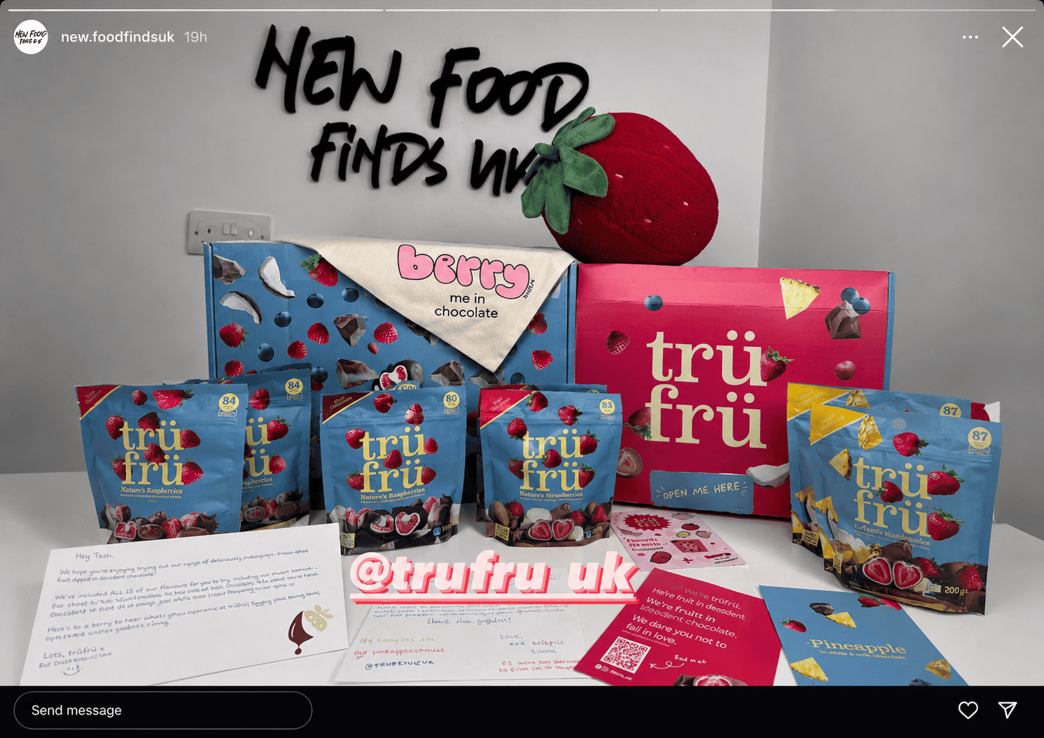 TruFru berry chocolate snacks with strawberry plush toy and product packaging.